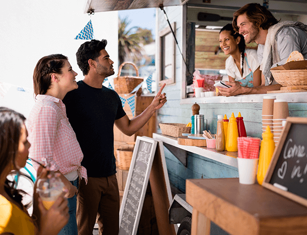Carro de venta de alimentos y personas comprando